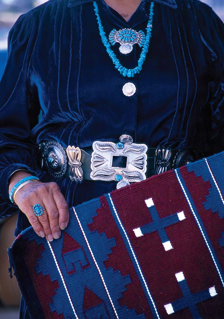 Navajo weaver Rena Begay holds a classic Chief rug outside her home in Pinon.