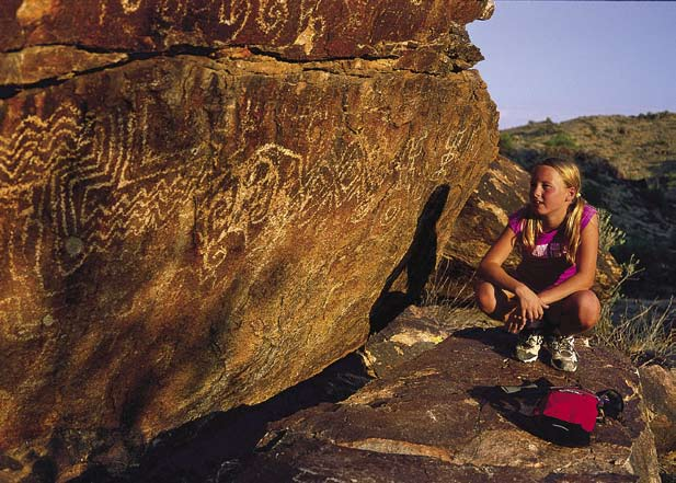 Audrey Elms, above, studies one of the many Hohokam petroglyphs that dot the 16,000-acre city-owned South Mountain Park in Phoenix.