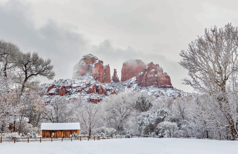 Cathedral Rock towers over a snowy landscape at Crescent Moon Ranch, a historic homestead in Sedona that now serves as a day-use area and picnic site.