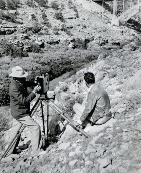 Wallace (left) and an unidentified assistant position a camera on a rocky slope to photograph a highway bridge. ARIZONA HISTORICAL SOCIETY