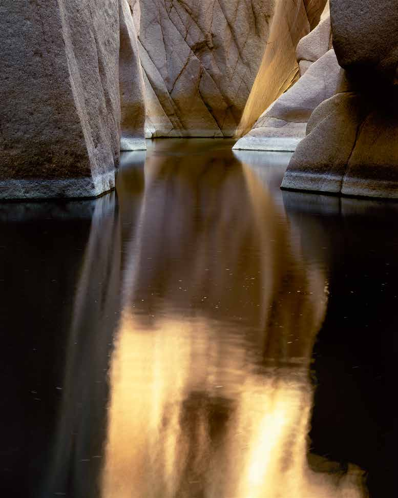 Sunset's reflected glow colors the confines of a creek along the Hell's Hole Trail.