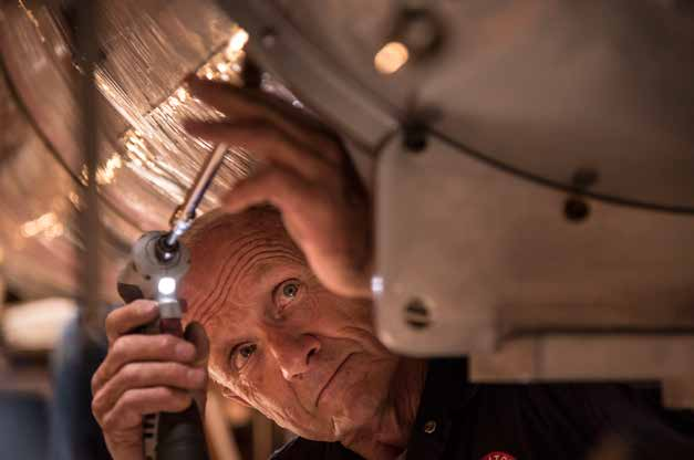 Lowell Observatory mechanical engineer Ralph Nye makes an adjustment on the facility's 24-inch Alvan Clark refracting telescope. Nye has been maintaining the Clark and Lowell's other telescopes since 1976.