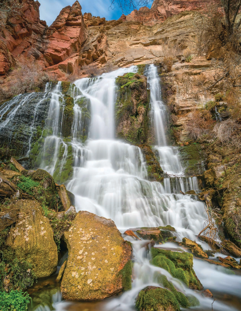 Mosses and other riparian plants thrive along part of Thunder River Falls in a view from below. The river's spring flows year-round, making the waterway a perennial river.