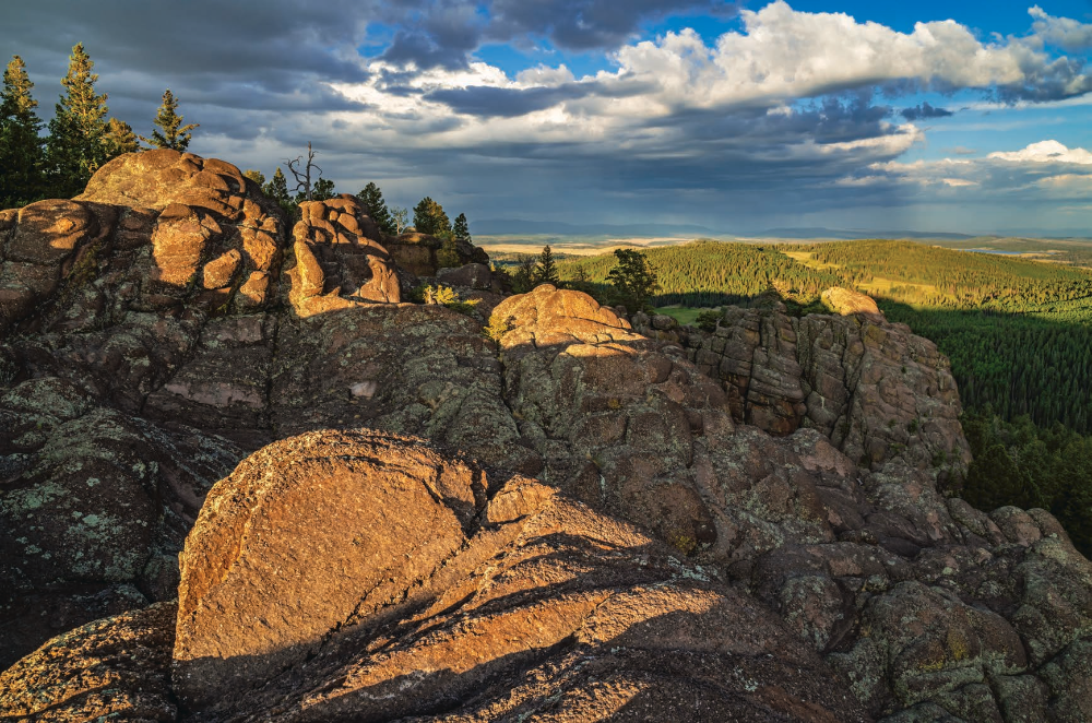 Long shadows fall on volcanic rock formations along the East Baldy Trail, in the White Mountains of Eastern Arizona, as a distant thunderstorm rages. East Baldy is one of two main routes that approach the summit of Mount Baldy, the White Mountains’ highest point. | Laurence Parent | SONY ALPHA 7R II, 1/25 SEC, F/16, ISO 200, 24 MM LENS
