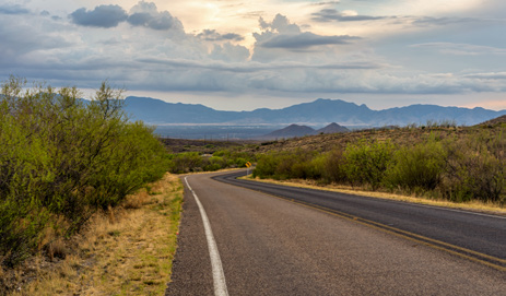 Heading out of Tombstone, the road curves toward the distant Huachuca Mountains.