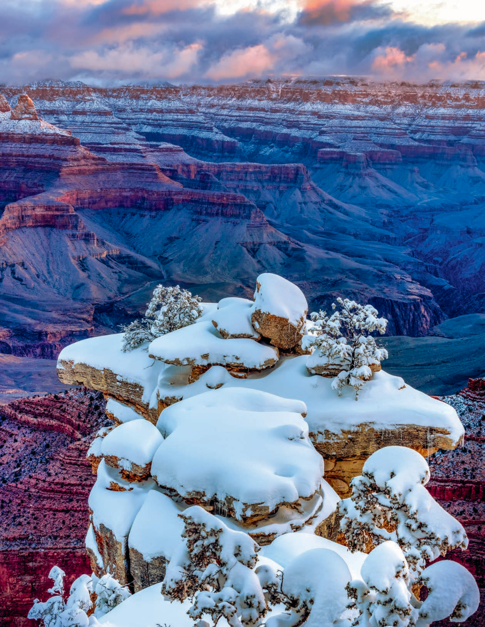 Heavy snow covers rocks on the South Rim during a winter sunrise. The South Rim averages almost 5 feet of snow per year; on the North Rim, the annual average is nearly 12 feet. | Gerry Groeber