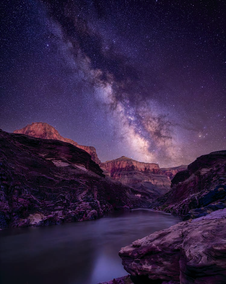 The Milky Way looms over the Colorado River as it flows through the Canyon. This view is from a rafting campsite along the river, looking downstream. | Shane McDermott