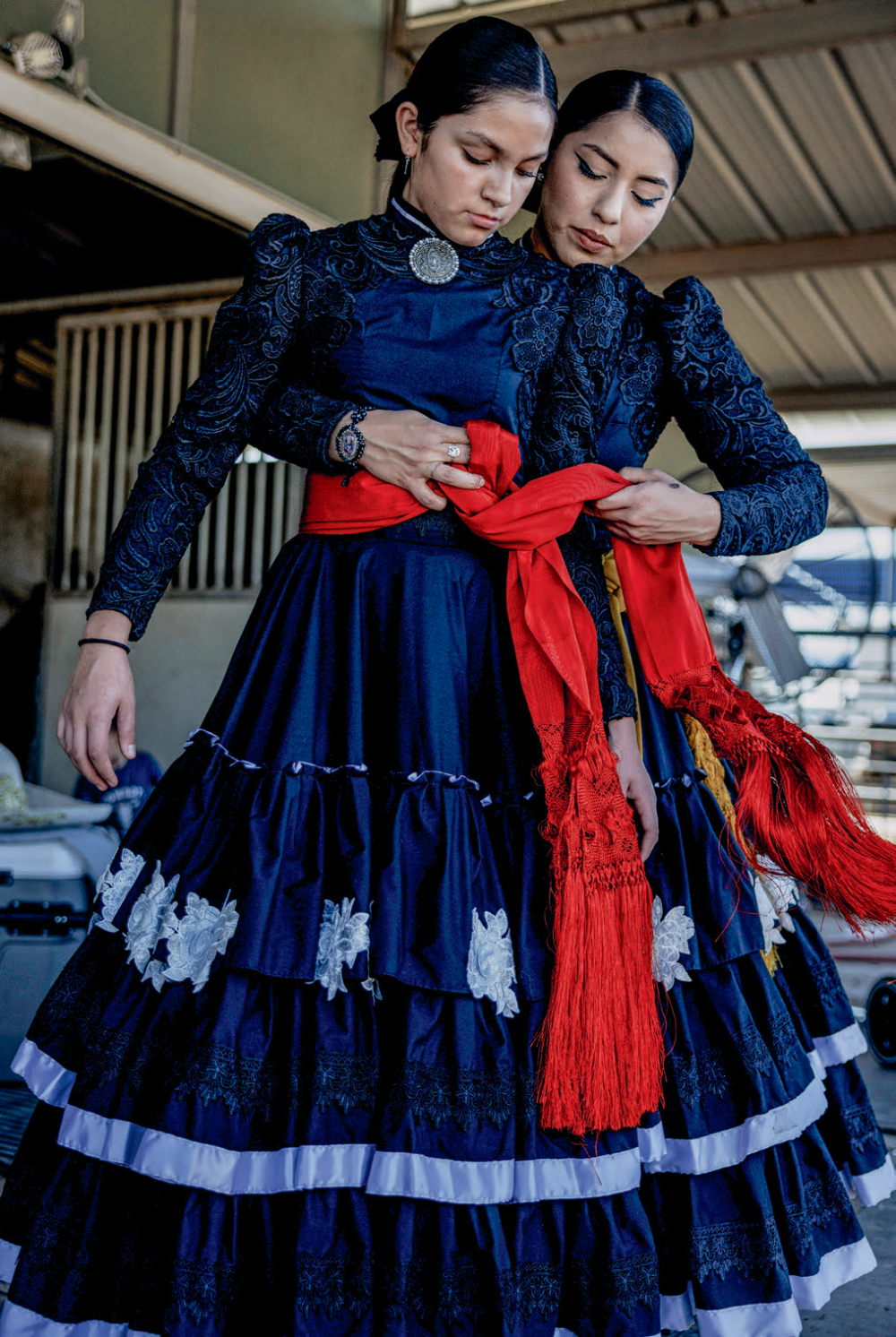 Amazonas de Corazón teammates Ana Ochoa (left) and Sol Reyes adjust their uniforms for an event at Rancho Corona. Ana is the granddaughter of longtime escaramuza rider Yolanda Campos.