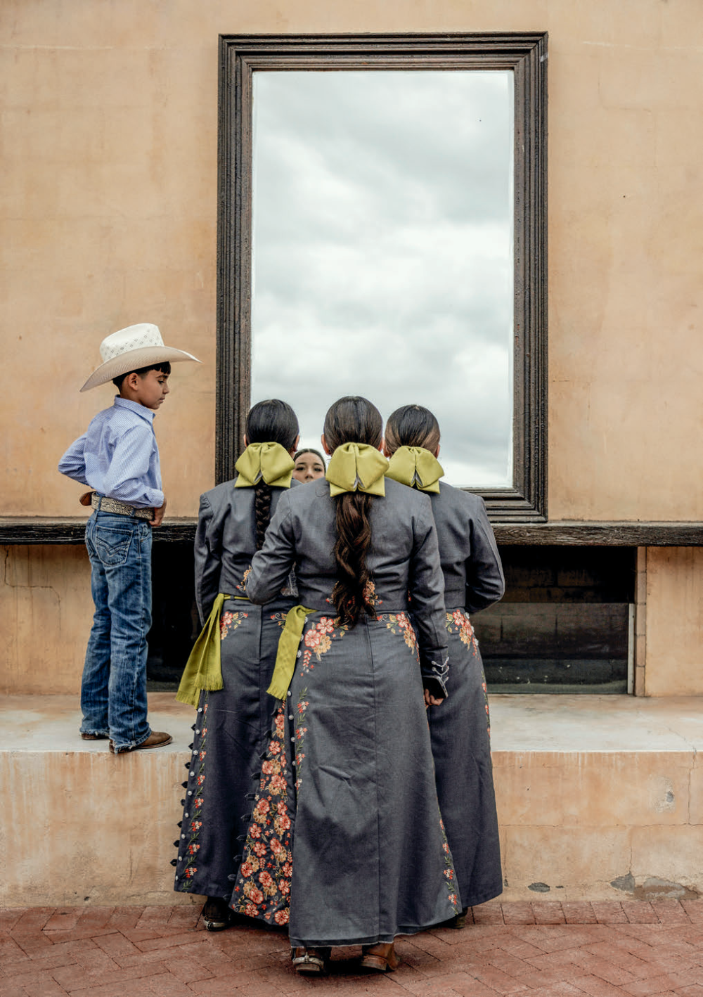 Team members check their makeup and ornate uniforms in a mirror before starting their performance