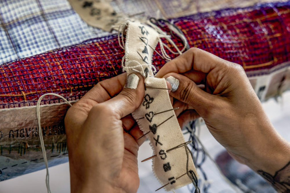 Martinez-Granados does cross-stitching for an ongoing art piece at her studio in Phoenix.