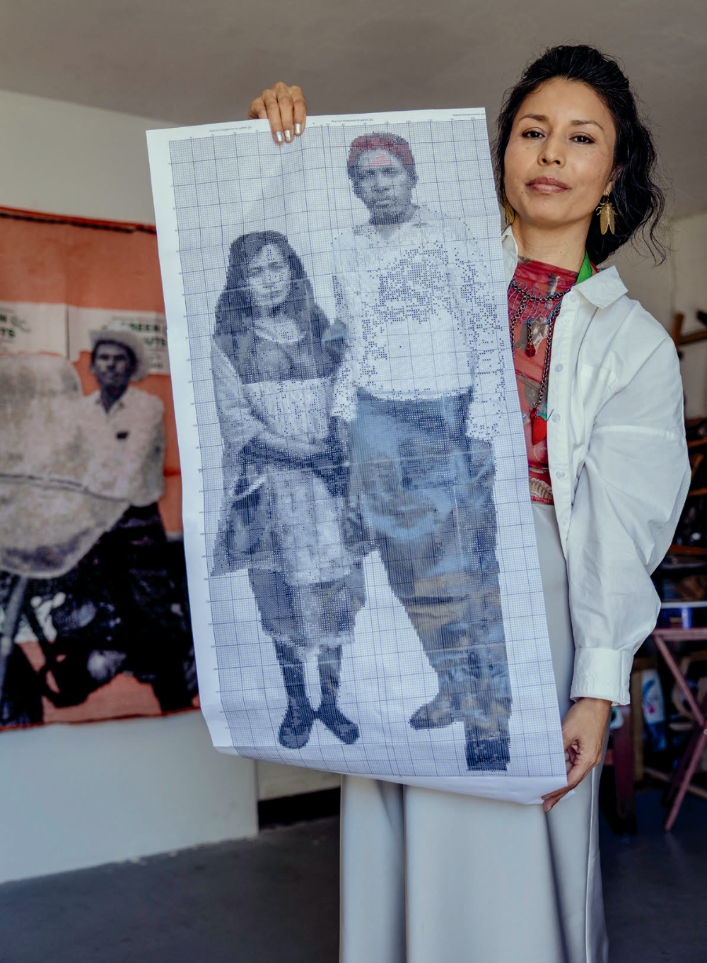 The artist displays a cross-stitch pattern of her paternal grandparents, who worked in the U.S. via the bracero program in the mid-20th century.