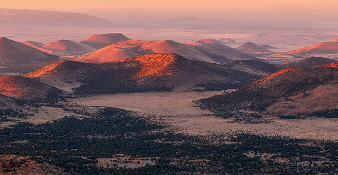 In another panorama from the area, golden light covers a cluster of dormant volcanoes.