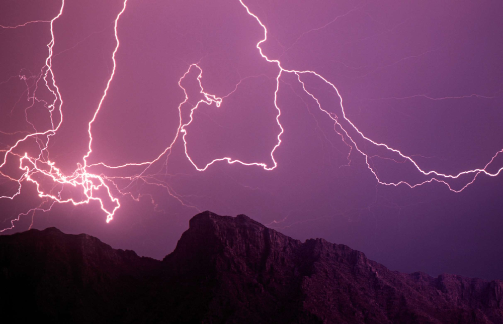 A rare event, lightning bolts travel from one cloud to another, moving sideways across the sky above Kellogg Mountain in the Santa Catalina range near Tucson.