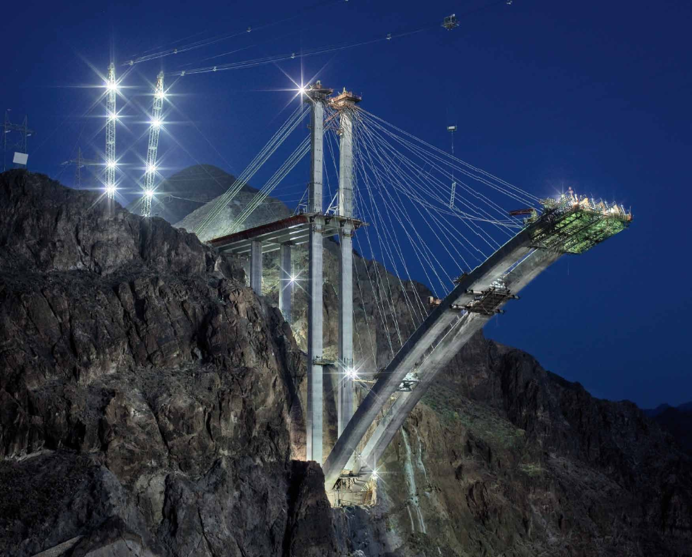 Made on the evening of April 29, 2009, this image of the Arizona arch segment of the Hoover Dam Bypass highlights the highline catenary system. Identified by the two lighted towers, the system transported most of the construction materials and workers out to the arch's construction area.