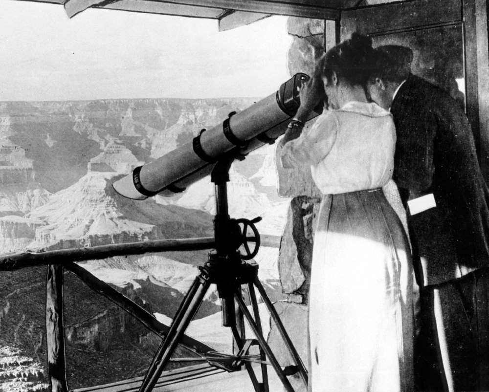 A couple views the Grand Canyon through a telescope at Lookout Studio. This photograph was made shortly after the studio's 1914 construction.