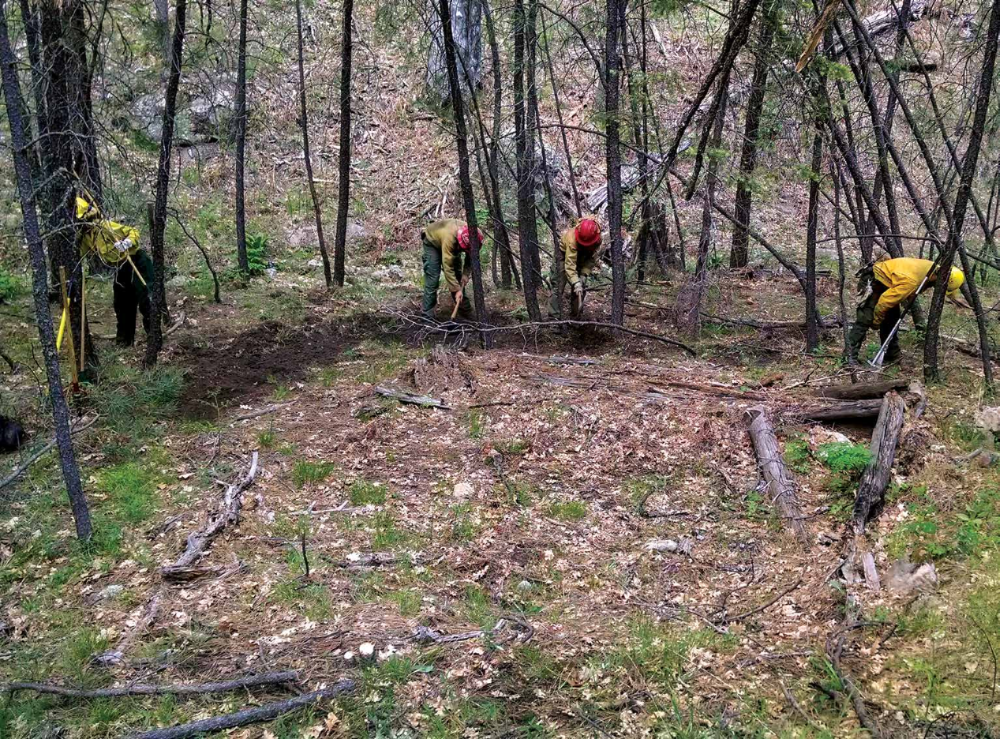 With the Slide Fire burning nearby, firefighters work to protect the remains of a cabin discovered in a remote area of Oak Creek Canyon.