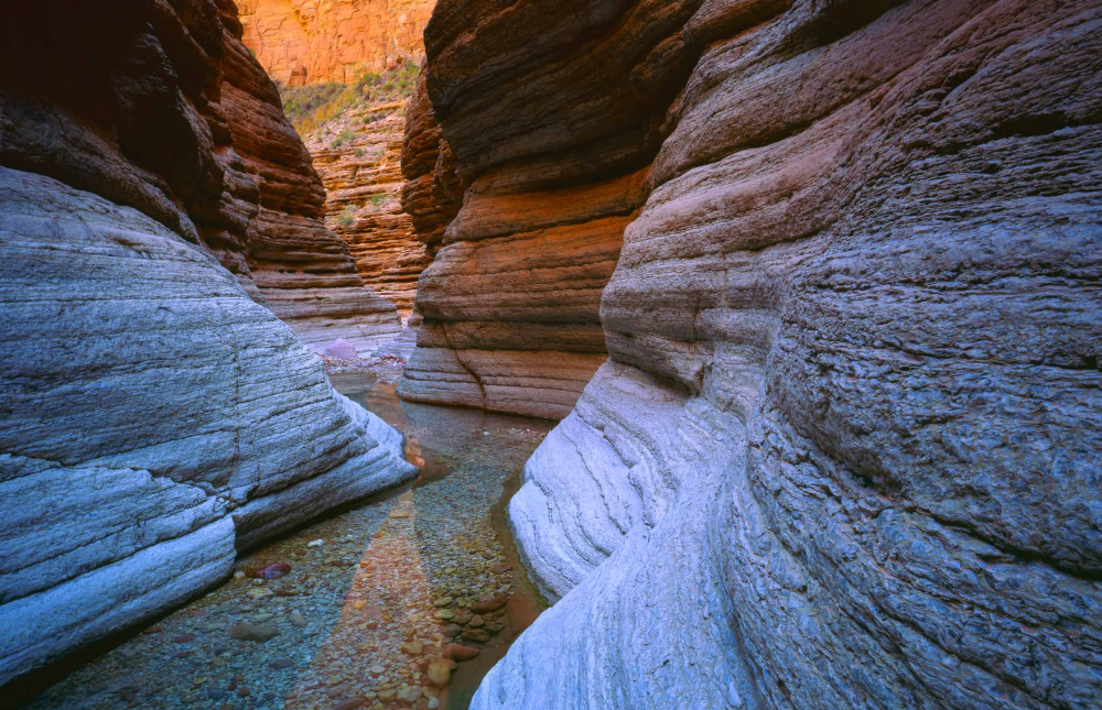 Clear water flows through the sculpted strata of Matkatamiba Canyon, a Grand Canyon tributary. The narrow slot canyon is a popular hiking destination.