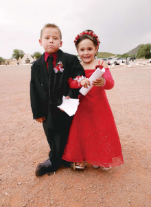 Her red dress befits Jasmine Encinas' joy as she clutches the arm of a stoic Jonathan Galindo outside the mission on October 1.