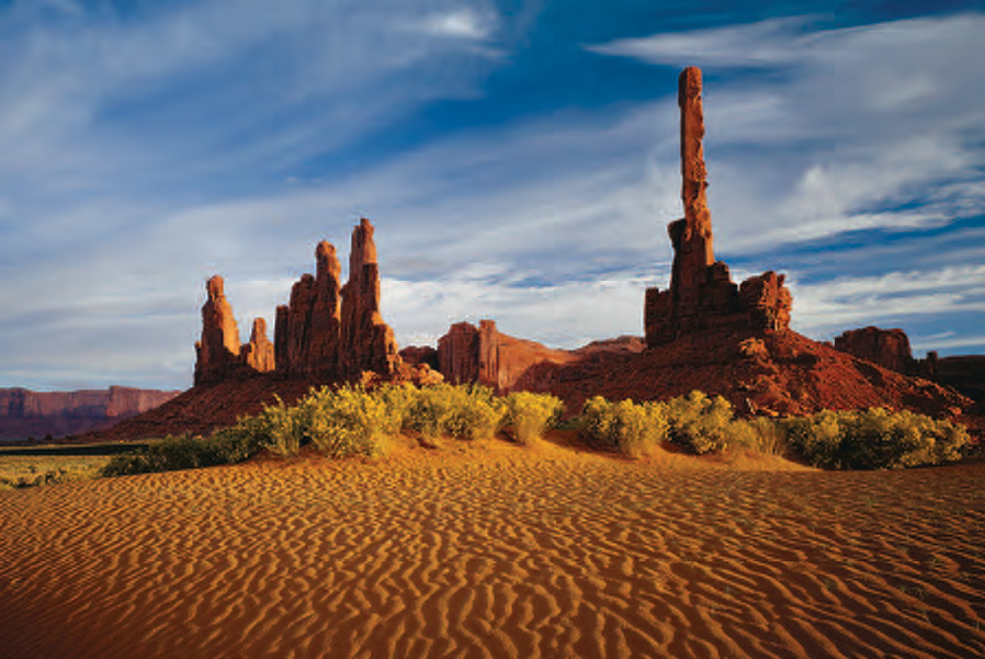 Rippled sand seems to emanate from the frozen-in-rock ceremonial dancers of Yei Bichei (left) and the vertical upthrust of Totem Pole.